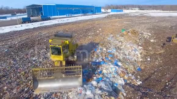 一台垃圾填埋场压实机推土机将一堆垃圾铲平视频的预览图