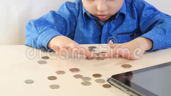 一个小男孩坐在桌子旁玩硬币视频的预览图