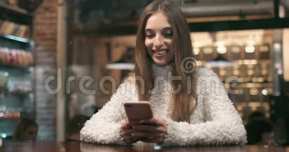 微笑女孩忙于使用智能手机视频的预览图