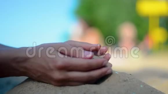 手特写放沙沙子在蓝色的海洋上流过暑假海滩度假视频的预览图