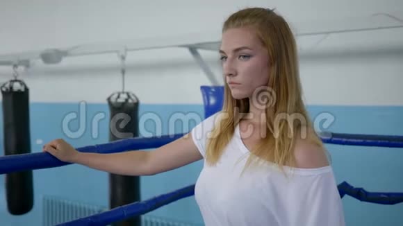 疲惫的女运动员在拳击场上经过艰苦的锻炼后从瓶子里喝水视频的预览图