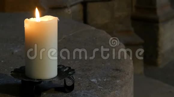 大蜡白色蜡烛燃烧站在德国一个古老的中世纪教堂的旧烛台上视频的预览图