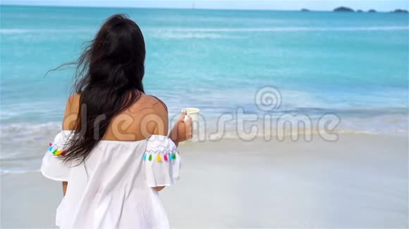 带着热咖啡的年轻女人享受海滩风景慢动作视频中的美女视频的预览图