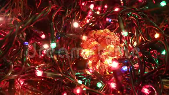 一棵圣诞树上的金色松果和闪烁的彩灯视频的预览图