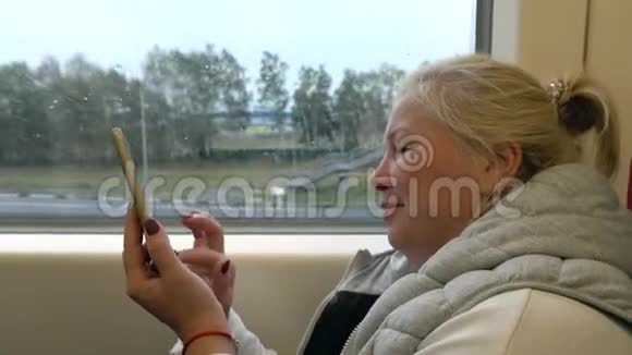 女人坐火车在手机上写信息视频的预览图