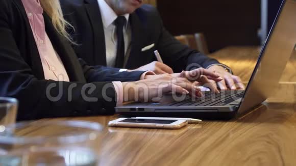 在电脑键盘上打字的女人的手的特写视频的预览图