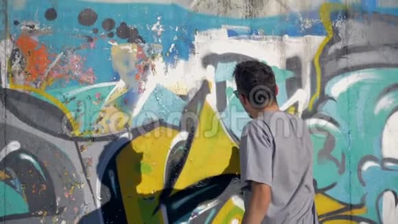 涂鸦艺术家正在黄色字母上画一个黑色三角形视频的预览图
