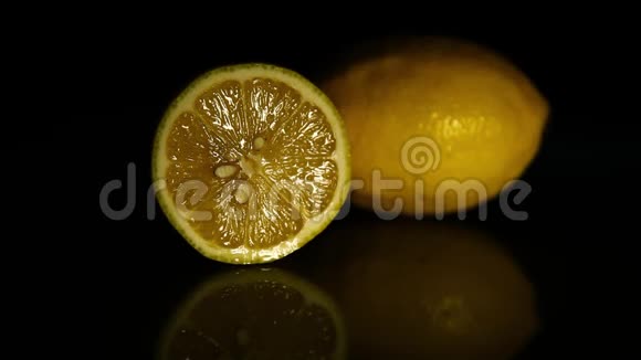 半个柠檬和一整个柠檬放在一张黑桌子上高清高清视频的预览图