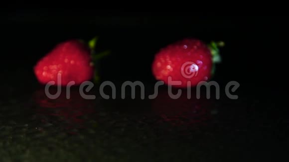 手在黑暗中把草莓放在潮湿的表面视频的预览图