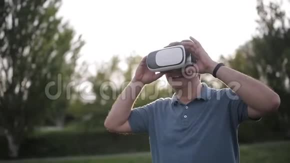 在公园的日落时分人们使用虚拟现实眼镜视频的预览图