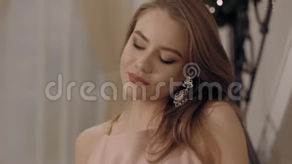 美丽的年轻女子穿着粉红色的裙子看着酒杯微笑着视频的预览图