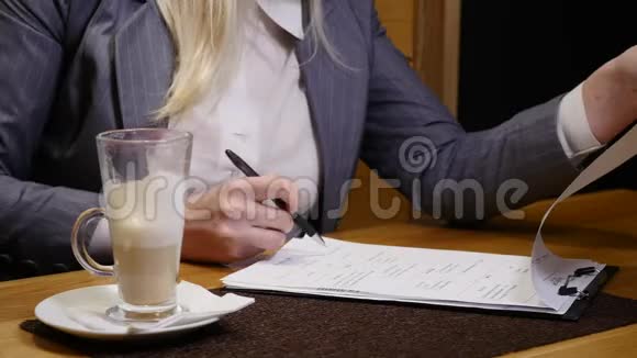 中年妇女在咖啡馆签合同视频的预览图