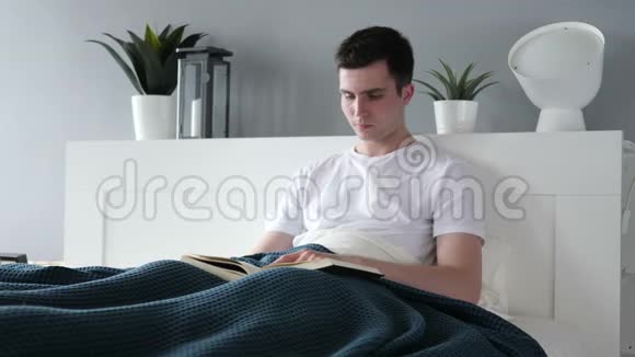 年轻人坐在床上看书视频的预览图