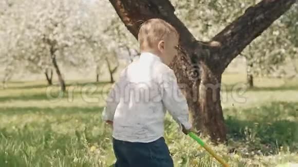 孩子在绿草上奔跑小男孩在城市公园的草地上迈出第一步视频的预览图