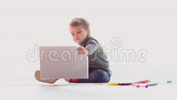 小男孩在白纸上画彩色铅笔视频的预览图