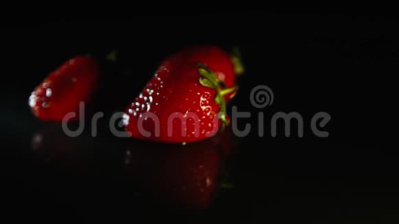 三个草莓在黑色背景上旋转视频的预览图
