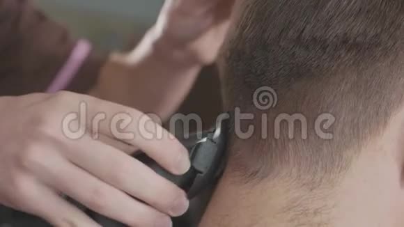 男理发师用电动剃须刀理发视频的预览图