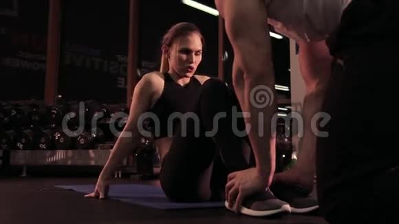 年轻女孩在健身俱乐部和教练一起做运动视频的预览图