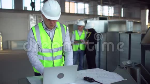 工程师在硬帽交谈笔记本电脑内部建筑在建暖通空调风管视频的预览图