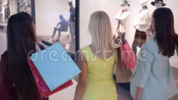 购物狂顾客女性朋友在打折和打折的季节在时尚精品店购物时穿过商场视频的预览图