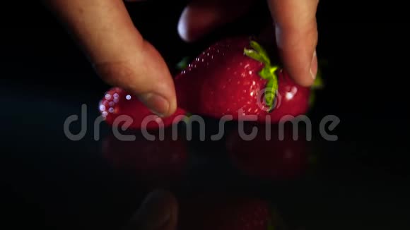 一个男人把草莓放在黑桌子上视频的预览图