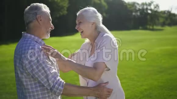 一对漂亮的老夫妇在草地上笑视频的预览图