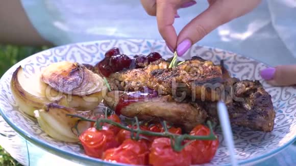 女人手装饰一盘肉西红柿和洋葱烤肉视频的预览图