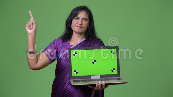 成熟美丽的印度女人展示笔记本电脑和指指点点视频的预览图