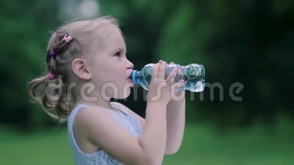 喝水小女孩在户外用瓶子喝水视频的预览图