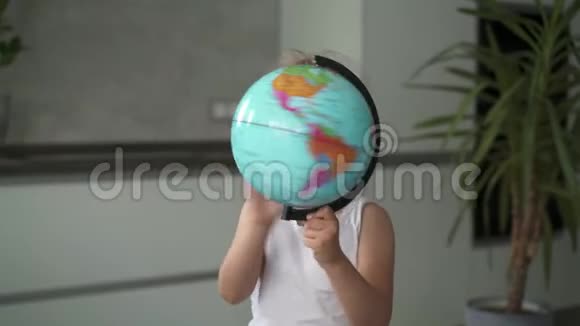 一个面目全非的小女孩在家里转动着地球仪视频的预览图
