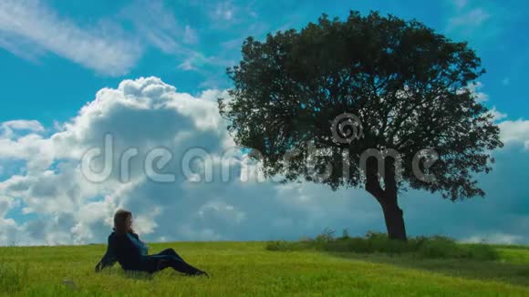 年轻女子在绿树下享受孤独与自然一起放松视频的预览图