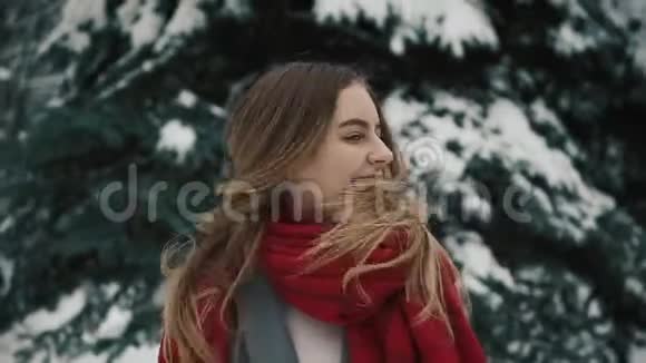 一个穿着温暖衣服的年轻漂亮女孩站在圣诞树附近长发摇着头慢慢视频的预览图