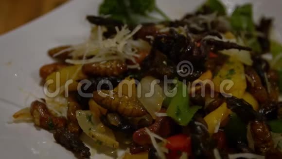慢动作的人在亚洲餐馆吃一盘虫子作为晚餐视频的预览图