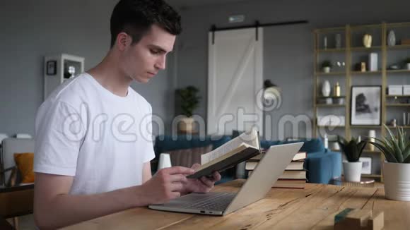 坐在书桌旁看书的年轻人视频的预览图
