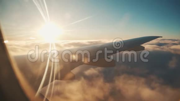 飞机飞行一架飞机的机翼在云层上方飞行天空是夕阳视频的预览图