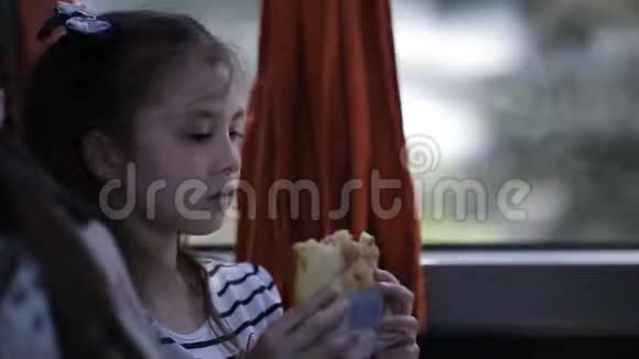 小女孩坐着旅游巴士吃着三明治视频的预览图