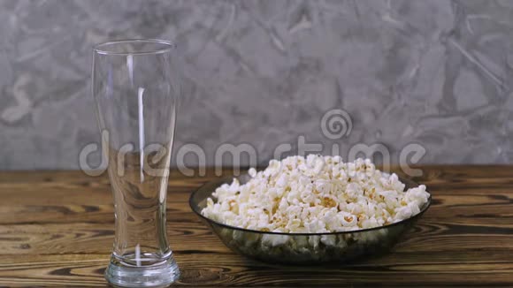 在满满一碗爆米花旁边的透明玻璃中倒入了火花水视频的预览图