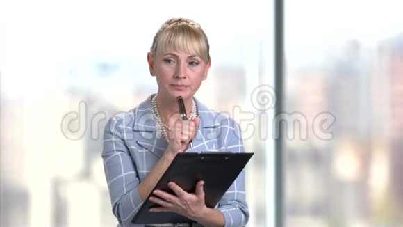 严肃成熟的商业女性在剪贴板上写作视频的预览图