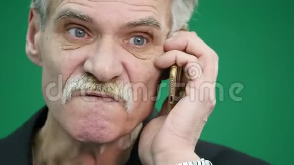 愤怒的老人在grren后台用手机说话视频的预览图