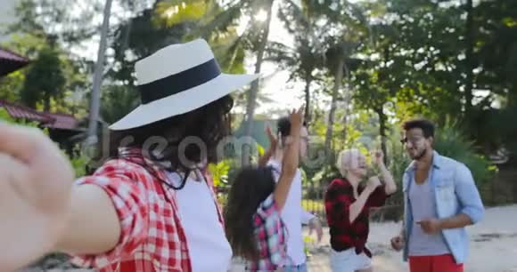 女孩欢迎人们团体在手机智能手机上自拍在热带棕榈树上谈论快乐的男人和女人视频的预览图