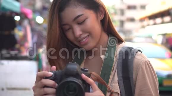 年轻女子拿着相机在泰国拍照视频的预览图