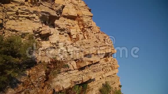 悬崖从黄色的石头在一个明亮的日子在海滨视频的预览图