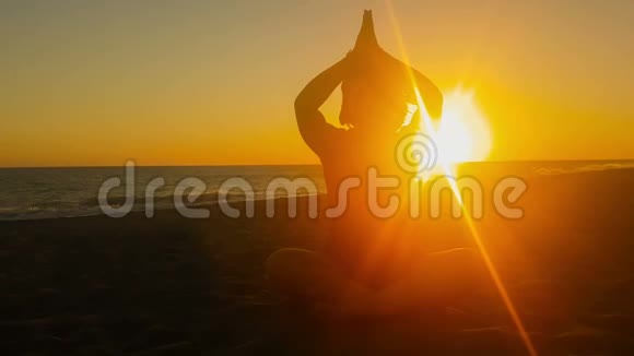 女人轮廓在美丽的夕阳下做瑜伽视频的预览图