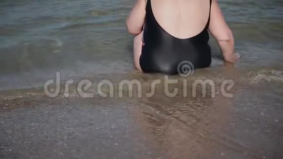 女人坐在海水里望着远处视频的预览图