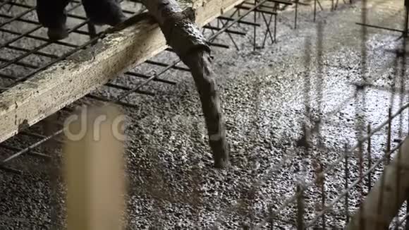 在一个工业工地上有一个工头用橡皮管把水泥灌满地板视频的预览图