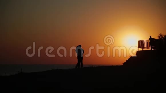 日落时站在悬崖上的朋友剪影视频的预览图
