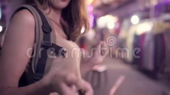 年轻的亚洲旅游女性背包客在高三路的城市街头夜宴上喝酒或啤酒跳舞视频的预览图