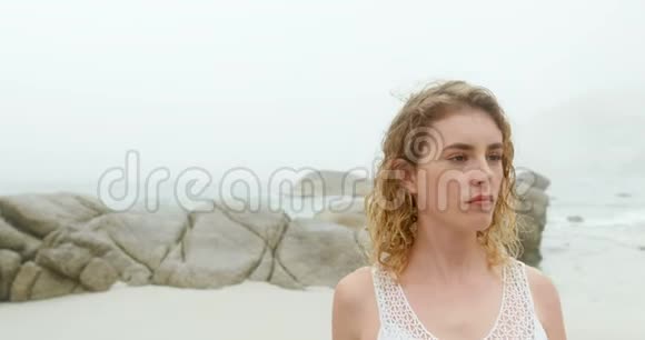 在海滩上做瑜伽的高加索女人的正面景色视频的预览图
