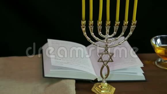 一个有蜡烛的门诺拉和一本关于罗什哈珊的节日祈祷书视频的预览图