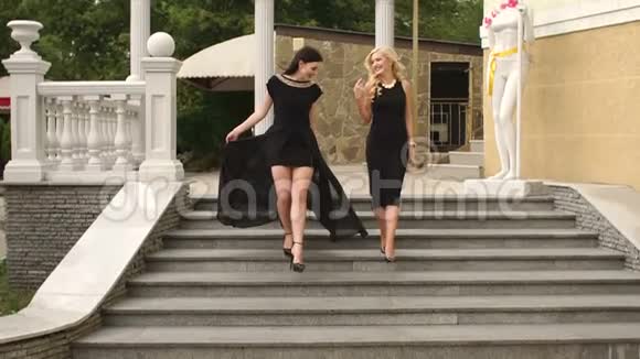 两个穿着黑色衣服的女孩走下楼梯视频的预览图